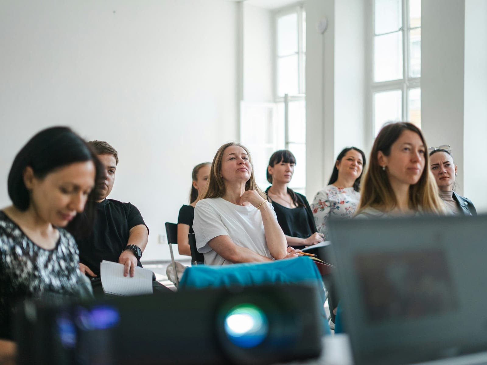 Adults listen during a training workshop in a bright room