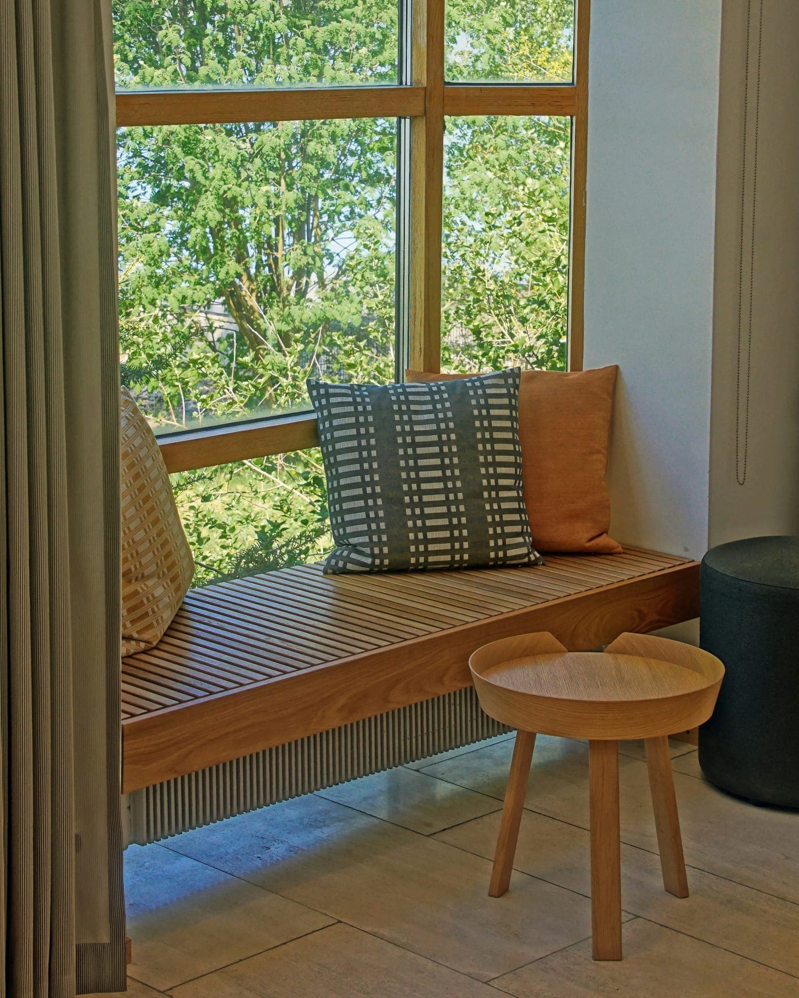 A quiet Nordic window seat looking out on birch trees